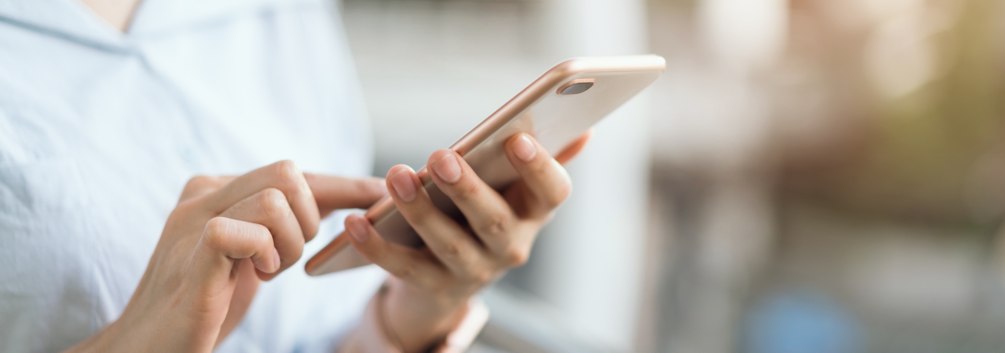 Woman in IT looking for a job, on her iphone about to contact XO Recruitment to see what jobs are available