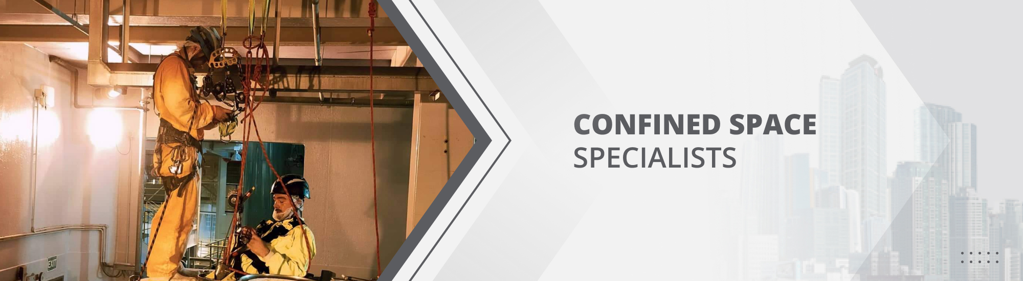 Two abseilers in their harnesses on top of a cylinder, maintaining the tank in a very confined space