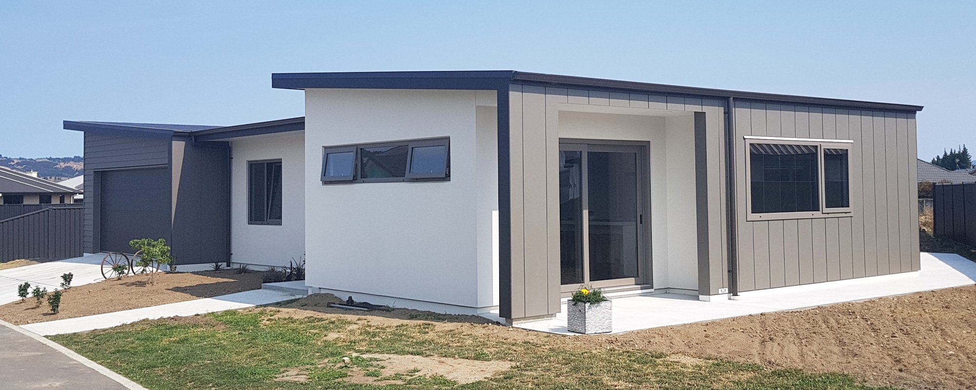 Modern newbuild home with a white, grey and black exterior and dark upvc window and door frames