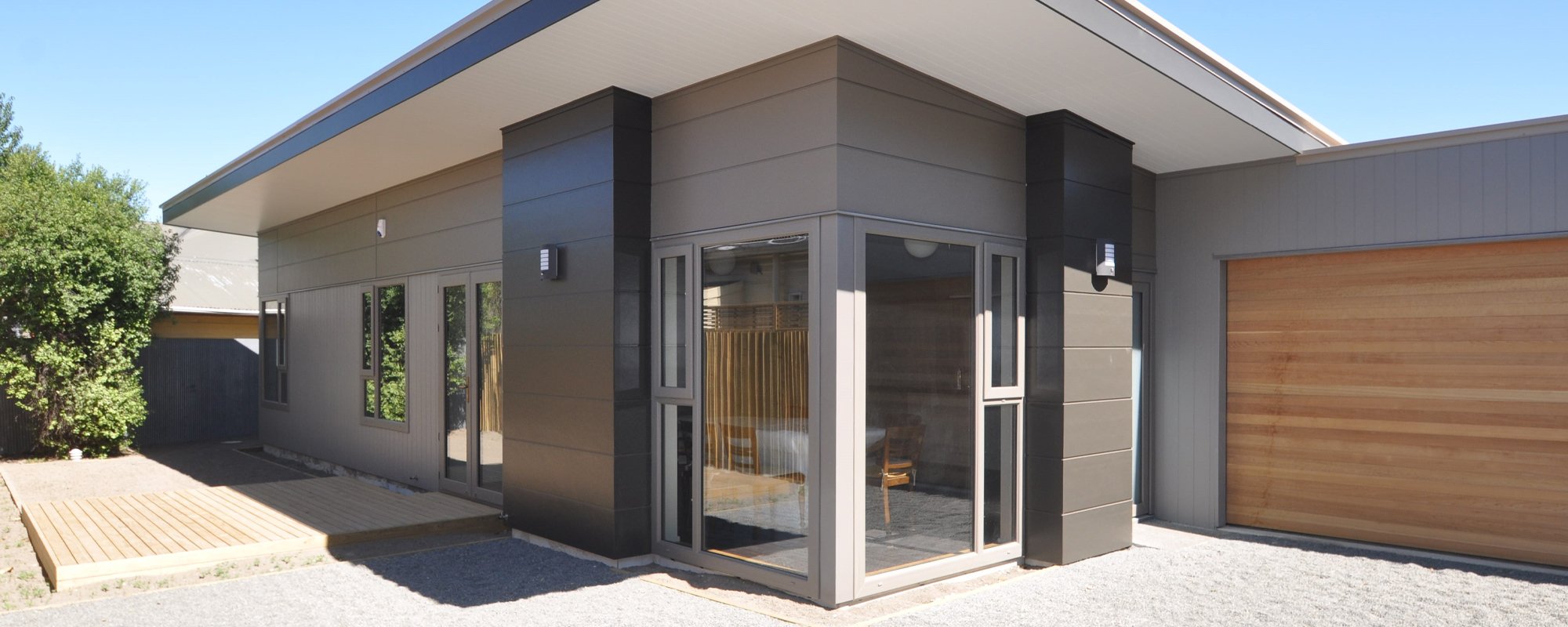 Modern grey, black and wooden house with grey uPVC window and door frames