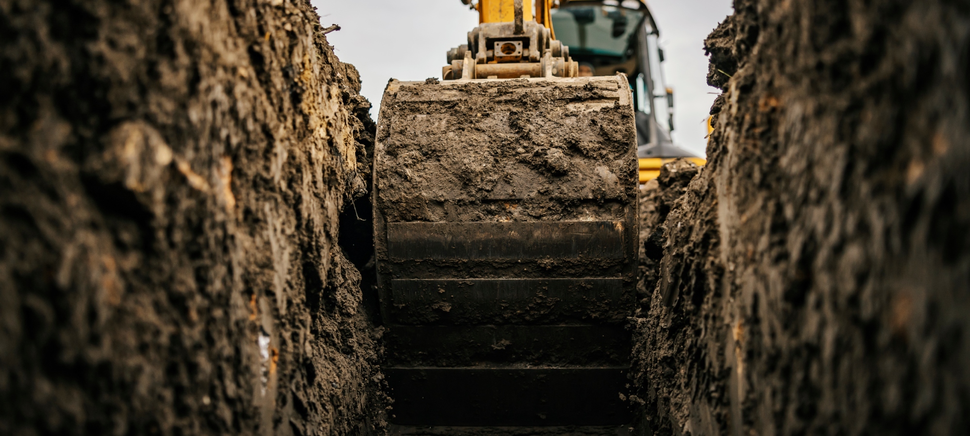 Orange A1 Bobcats & Concrete Digger emptying out a trench in the dirt for your home's foundation