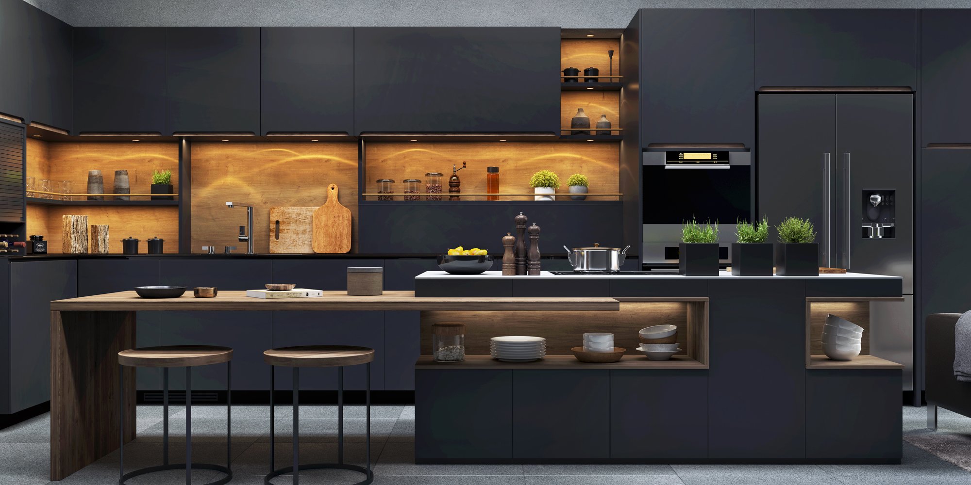 Very dark coloured kitchen with smoothly designed cabinets and appliances, warmed by orange lighting