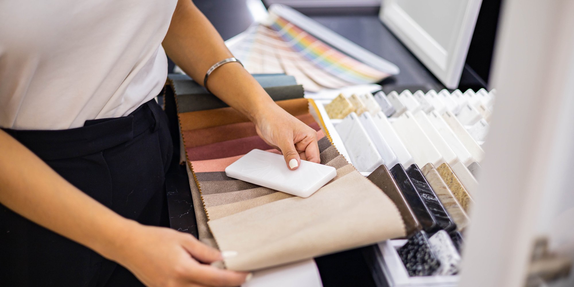 Lifestyle Kitchen & Bathrooms' interior designer comparing the contrast between a slab of stone and different fabrics