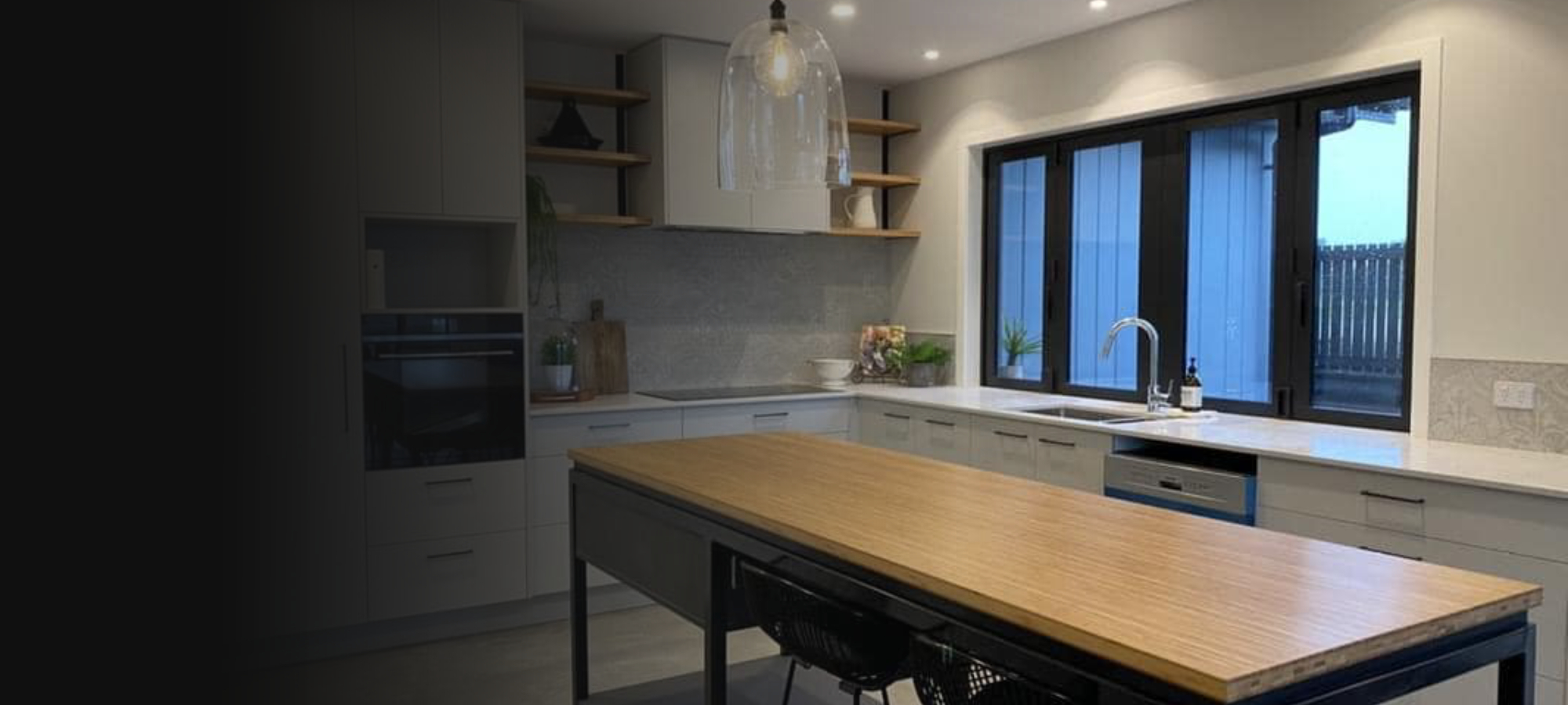 Stylish kitchen with off-white walls, white cabinetry and oak wood accents on the shelves and island benchtop