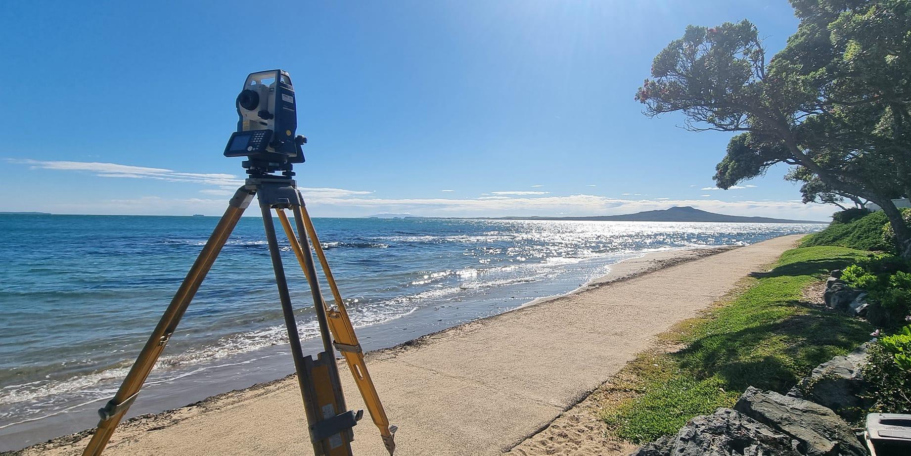 surveying equipment with Rangitoto in the background