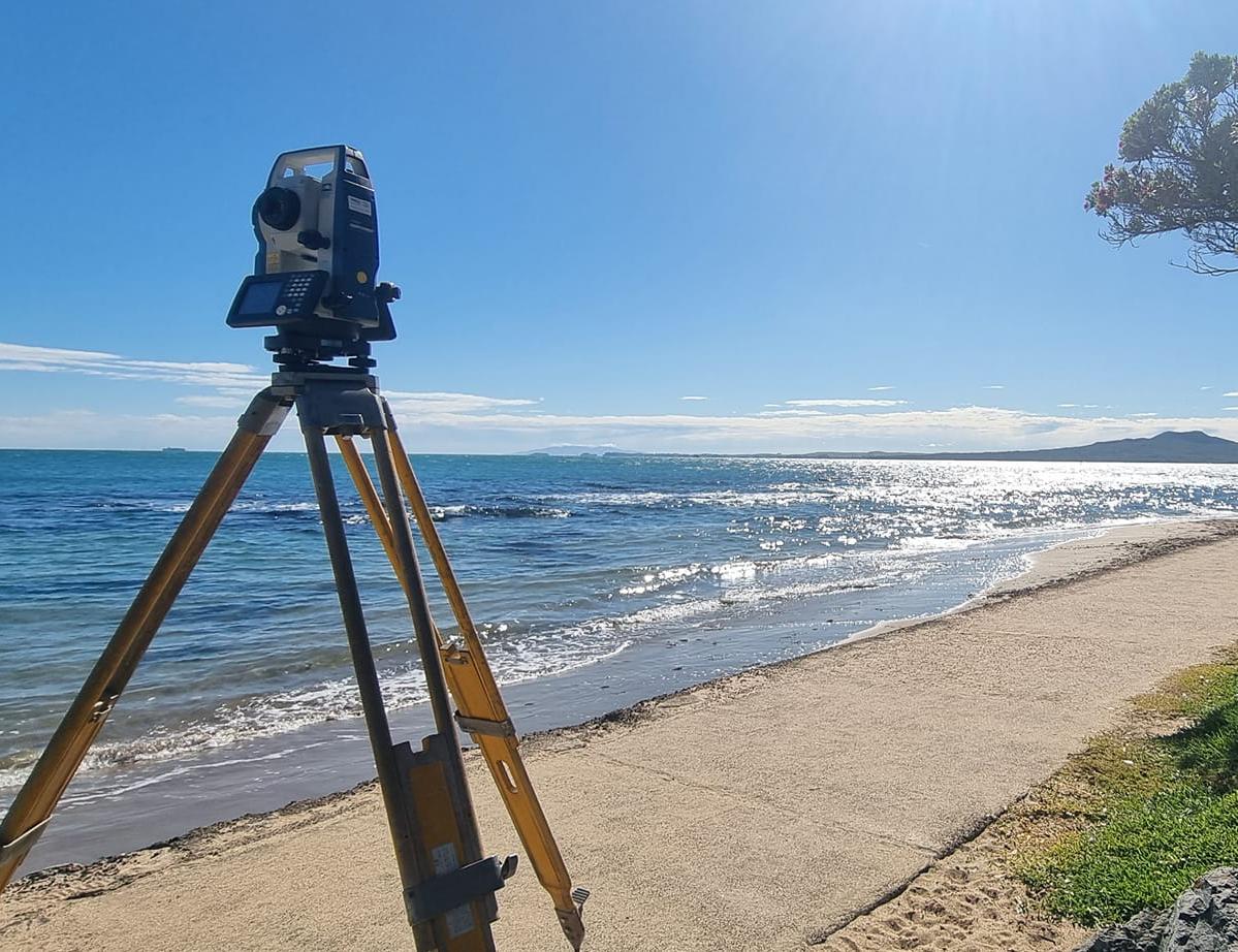 surveying equipment with Rangitoto in the background