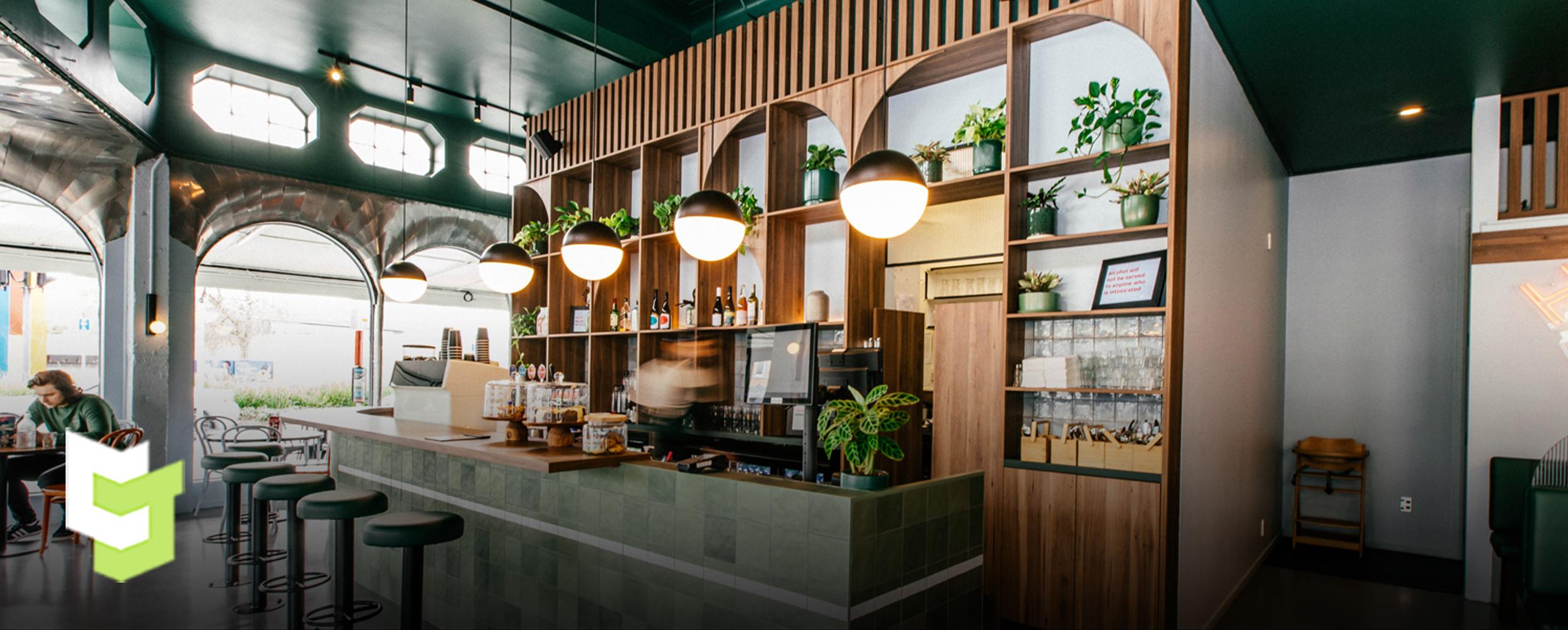 Hood street bistro's wall behind the register, designed beautifully and earthy with wood joinery and heaps of plants