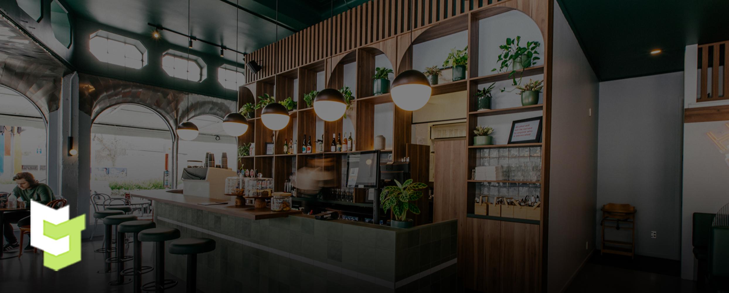 Hood street bistro's wall behind the register, designed beautifully and earthy with wood joinery and heaps of plants