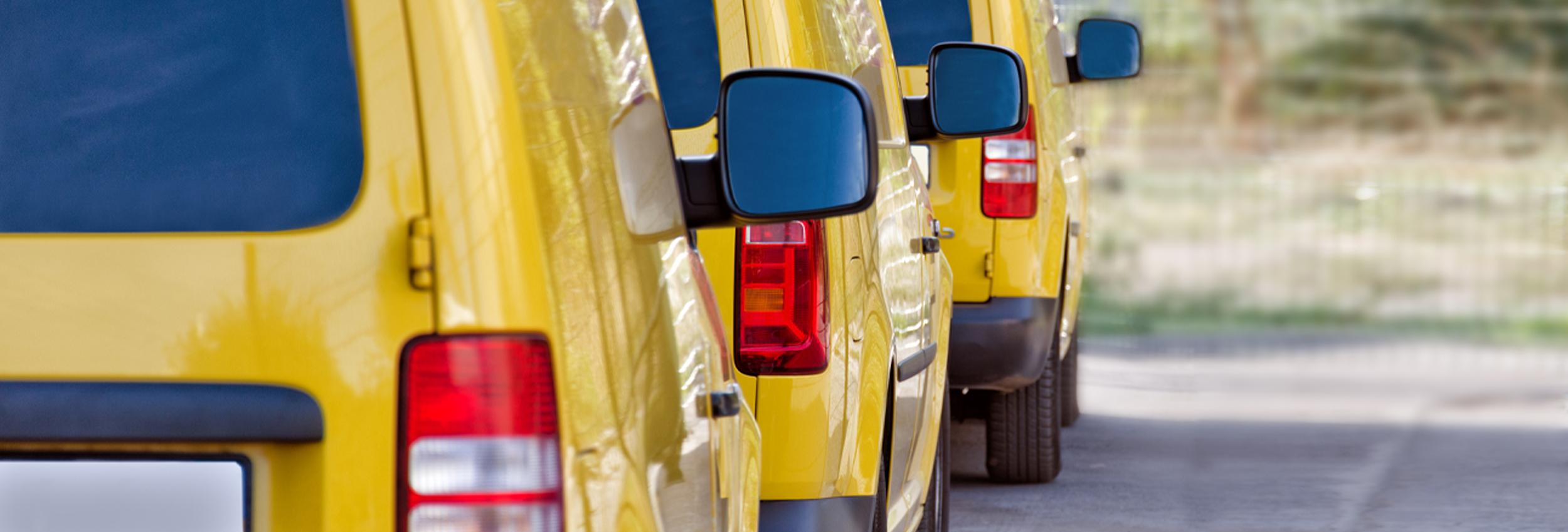 Three yellow work vans in perfect condition, so clean you can see your reflection in the paint