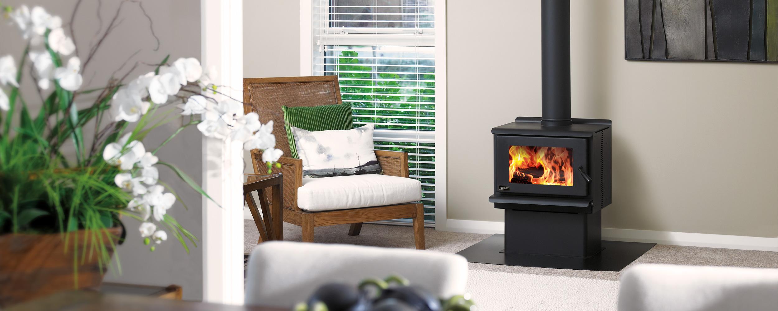Indoor sitting area with modern furniture and a lit black Kent freestanding wood fire