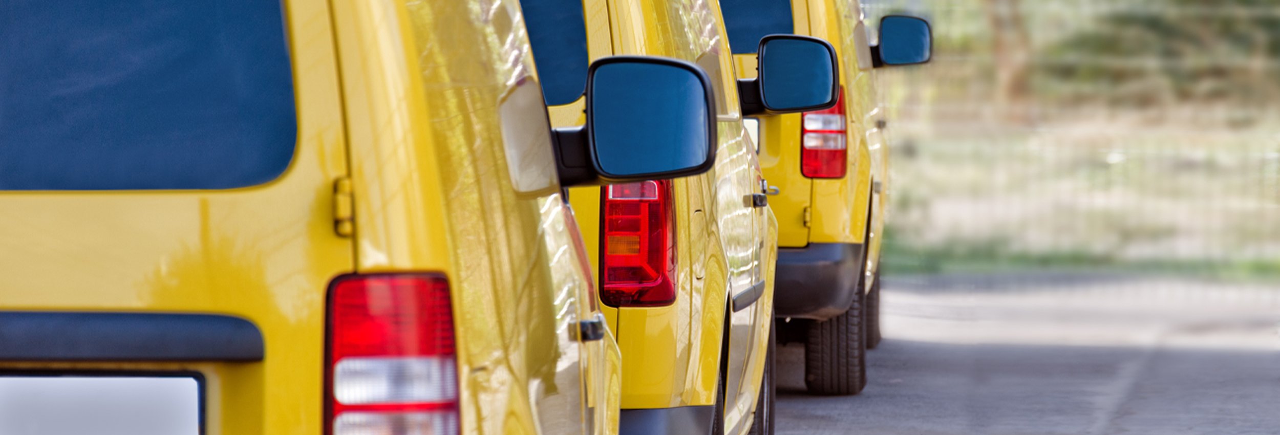 Three yellow work vans in perfect condition, so clean you can see your reflection in the paint