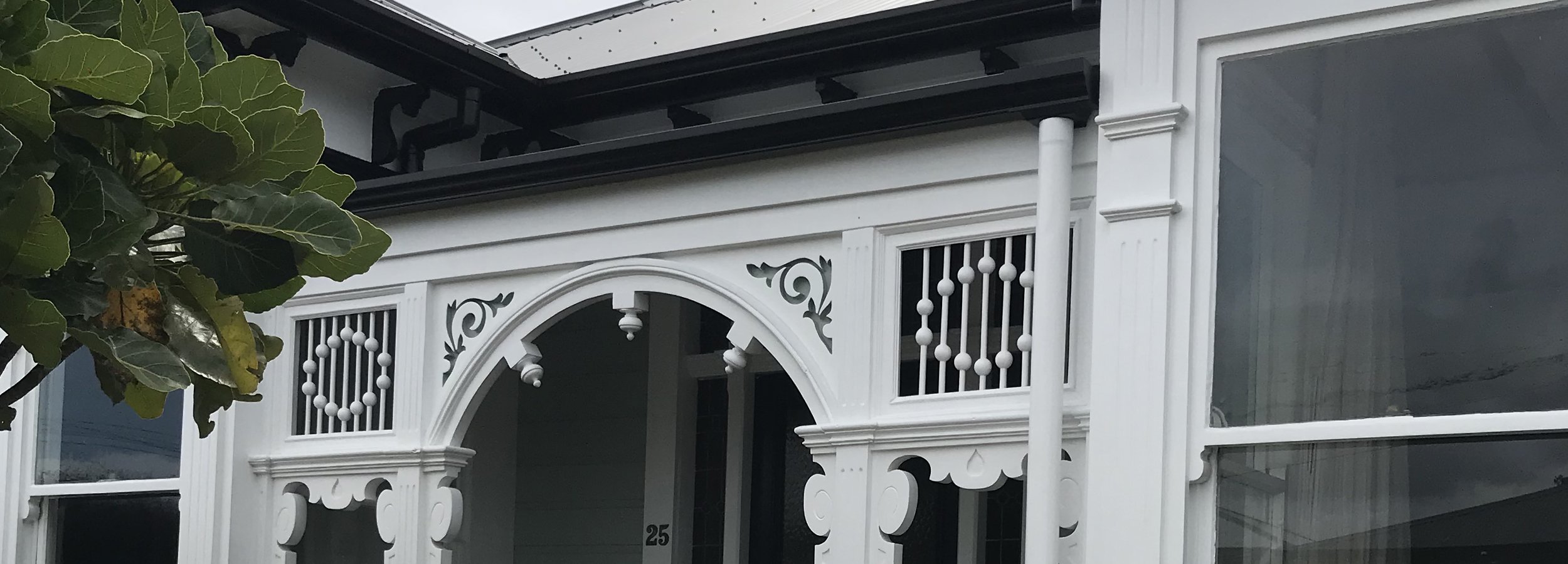 Wellington residential home with an old-fashioned front patio arch newly updated with a fresh coat of white paint