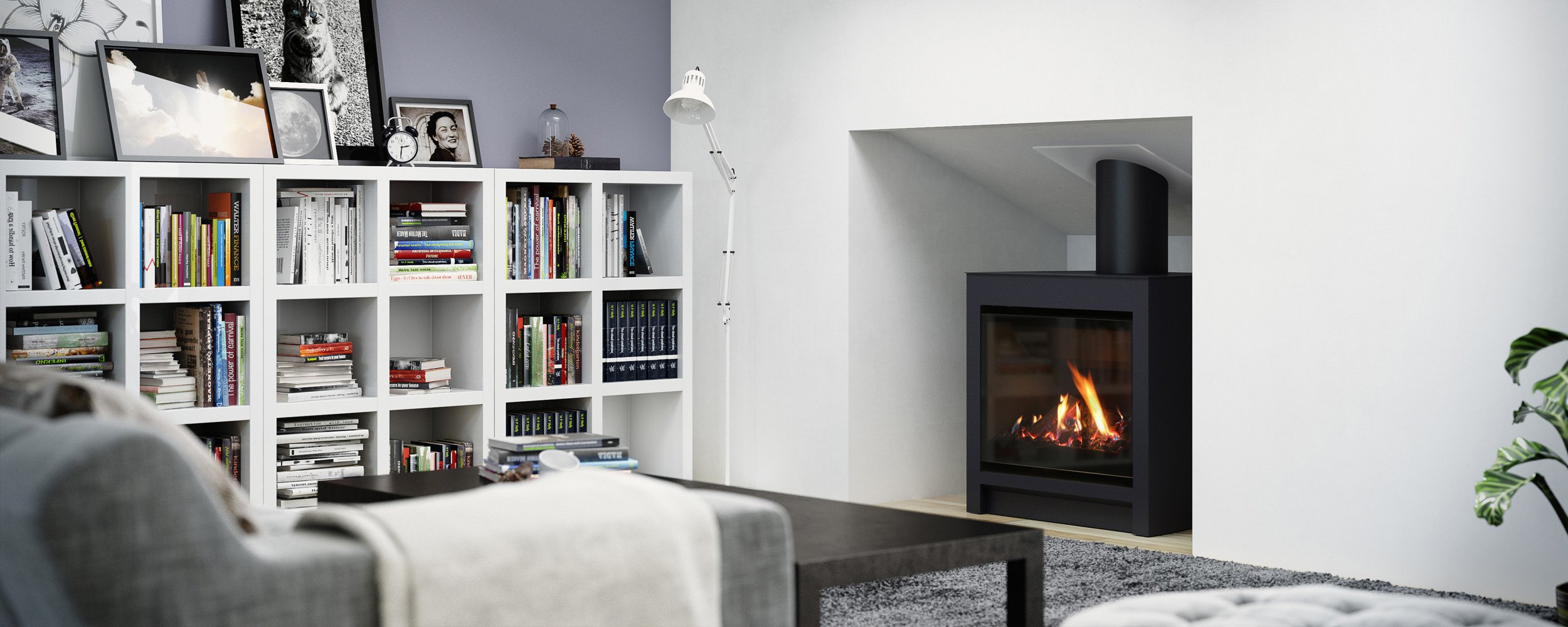 Cozy white room with a grey couch, filled white bookshelf, and a built in cubby that holds a large freestanding black gas fire