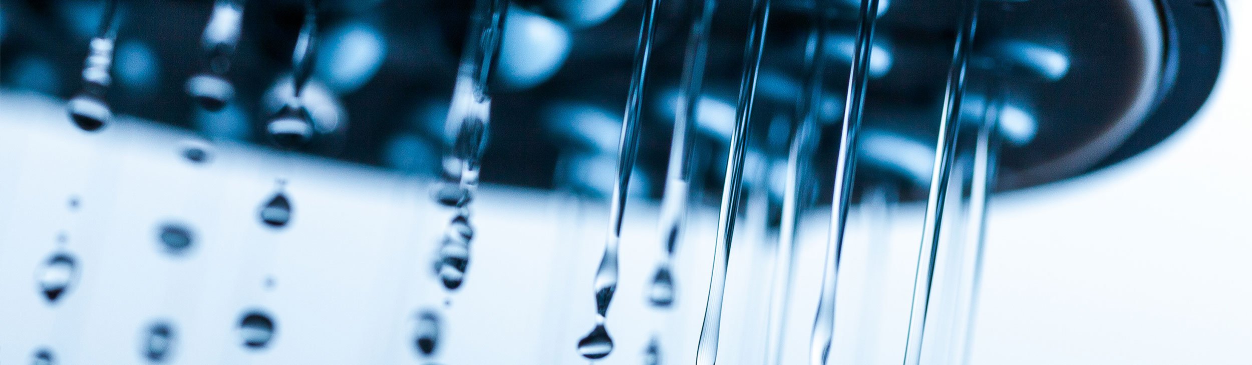 Close up of a shower head with crystal clear water droplets spitting out 