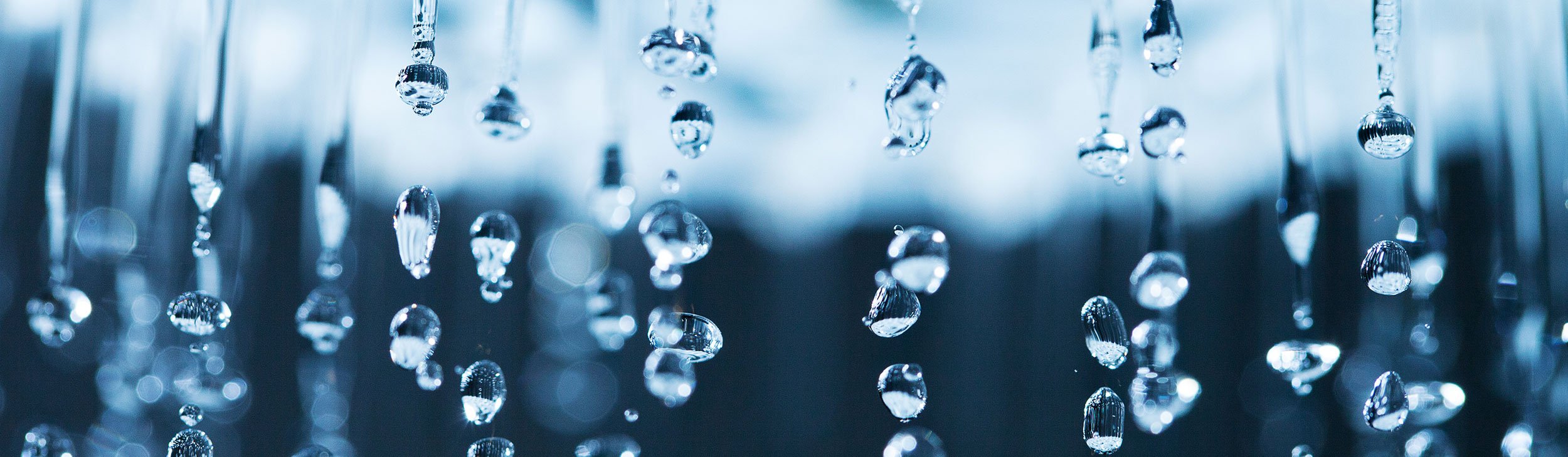 Close up of a shower head with crystal clear water droplets spitting out 