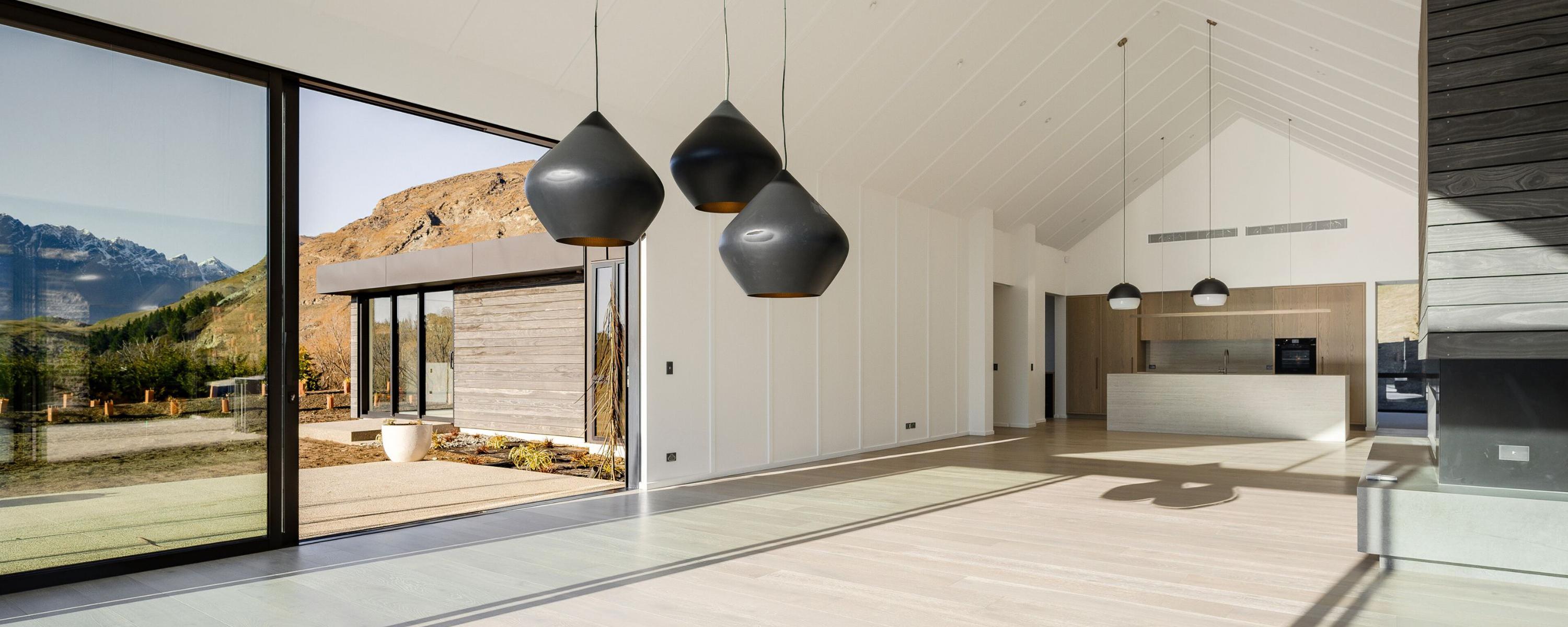 Inside an empty new home's living/dining/kitchen area with slider glass doors | Painting Company Queenstown, Wanaka, Cromwell, Alexandra