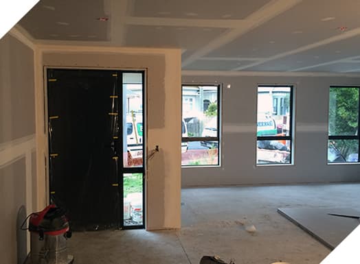 Interior plastering in new home build with company vans parked outside