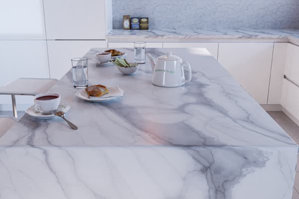 Beautiful white quartz kitchen waterfall island with a meal and tea set for two, in a kitchen with white minimalist cabinets