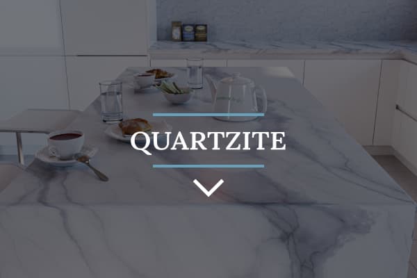 Beautiful white quartz kitchen waterfall island with a meal and tea set for two, in a kitchen with white minimalist cabinets