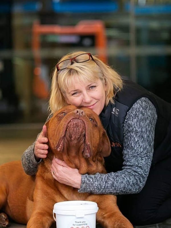 Carolyn Press McKenzie giving a hug to a large ginger dog