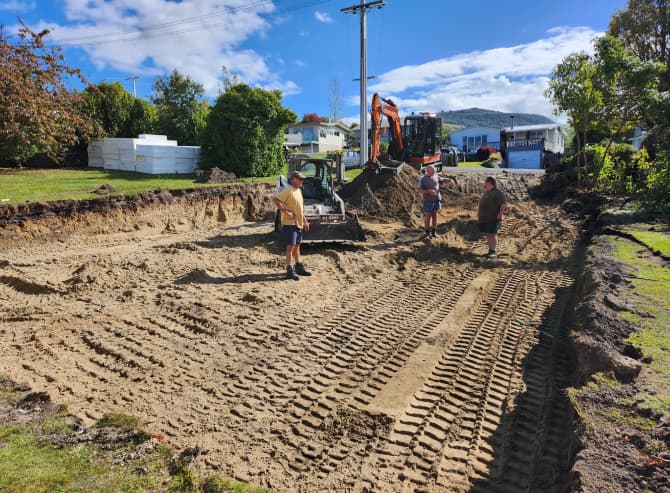 Three members of the A1 Bobcats & Concrete team standing with their heavy machinery on a recently laid sand pad