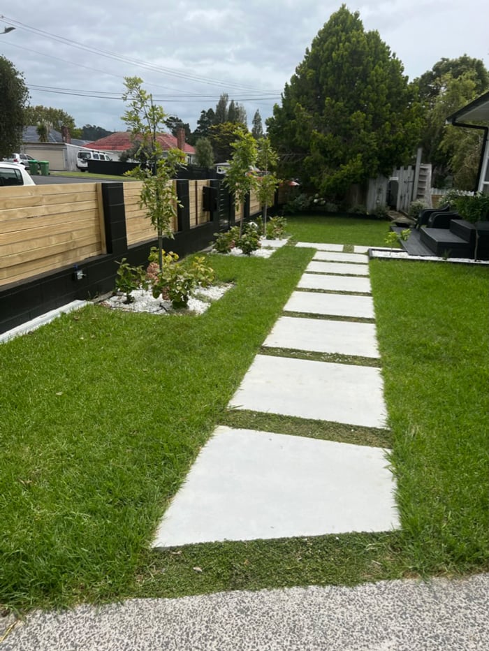 Large concrete tiles amongst the grass in the front yard to provide a path from the driveway to the front door