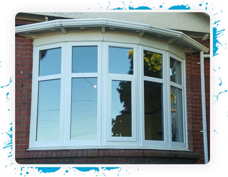 Orange brick facade on an old house with a new white uPVC window framed bay window