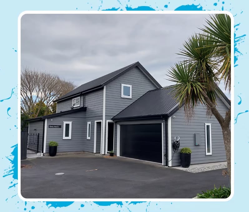 Two-story grey and black house with contrasting white uPVC window and door framing 