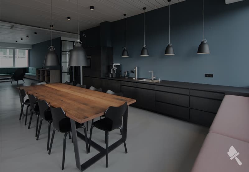 Modern kitchen with a matte blue painted wall, sleek black painted cabinetry, 10 seat dining table with a fine wood top