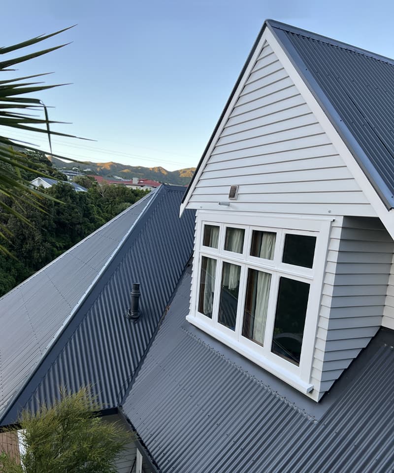 Second story exterior of a flawlessly painted white house overlooking the hills of Wellington