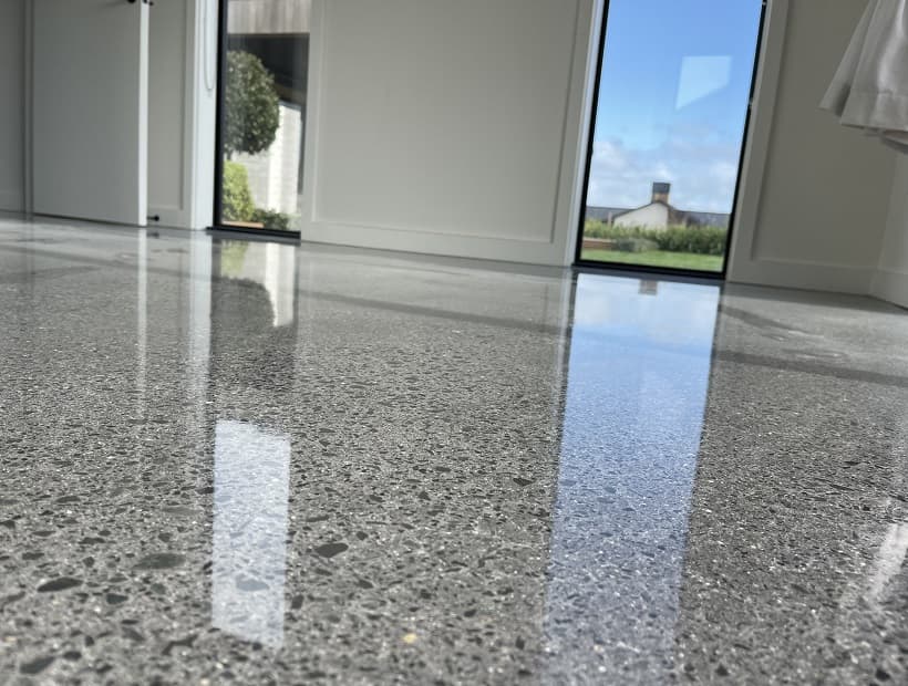 Extremely reflective polished concrete floor in a residential home with a nice garden showing through the windows
